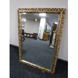 An ornate gilt framed bevel edged overmantel mirror