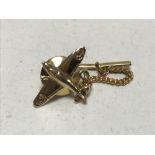 A 9ct gold spit fire tie pin on gilt mount