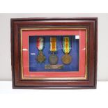 A framed set of three WWI medals presented to John Simm of Durham Light Infantry