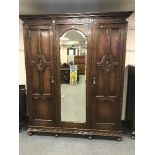 An Edwardian oak triple door mirrored wardrobe,