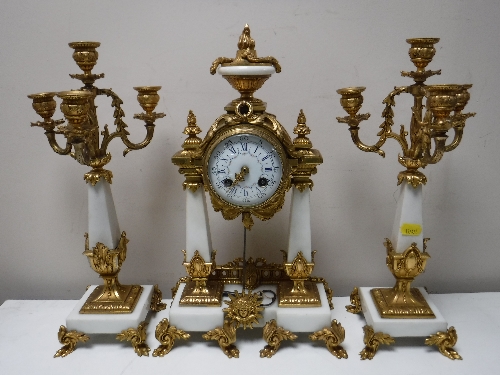 A three piece French white marble and brass clock garniture,