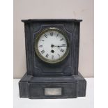 A late nineteenth century black slate mantel clock with enamelled dial