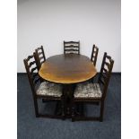 An oval oak extending table and five ladder back chairs