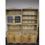 A 20th century blonde oak twin section bookcase fitted cupboards beneath