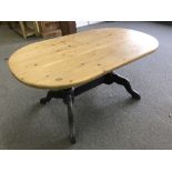 An oval pine kitchen table on painted base