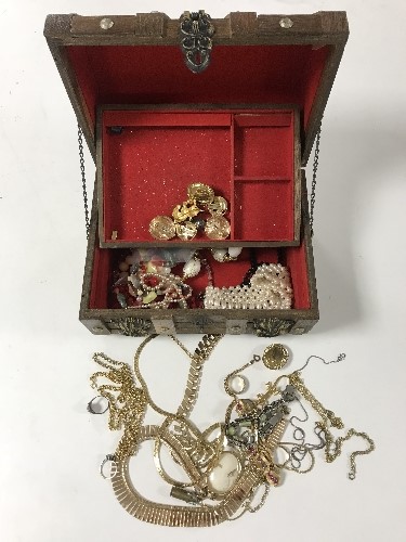 A casket jewellery box containing assorted costume jewellery including two gold and silver rings,