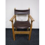 An antique oak armchair upholstered in brown button leather