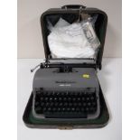 A cased Remmington typewriter and a bag of table linen