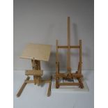 Two folding easels, together with a boxed tapestry frame,