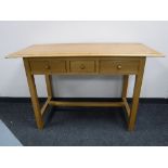 A contemporary oak side table fitted 3 drawers
