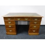 An Edwardian oak twin pedestal desk with green leather inset panel