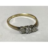 An 18ct gold three stone diamond ring, size N/O, 1.5g.