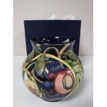 A Moorcroft vase decorated with tubelined floral decoration, boxed.