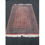 A fringed woolen rug on pink ground