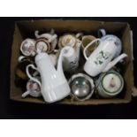 A box of china and pottery teapots, lidded biscuit barrels,