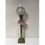 A Victorian oil lamp with pink glass bowl