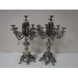 A pair of white metal candelabrum on stands