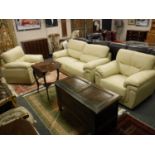 A cream leather three piece lounge suite comprising of two seater settee and pair of armchairs