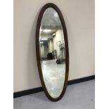 An inlaid oval mahogany dressing table mirror