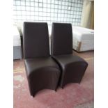 A pair of brown leather high backed chairs