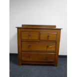 An Edwardian oak four drawer chest