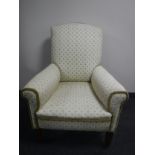 An Edwardian mahogany framed armchair upholstered in cream floral fabric