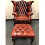 A Burgundy buttoned leather Chesterfield style armchair with matching stool