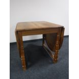 A blond oak drop leaf dining table