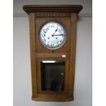 An early twentieth century oak cased wall clock with silvered dial