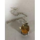 An 18ct white gold mounted citrine pendant suspended upon a silver chain