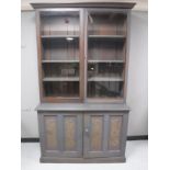 A painted Victorian glazed door bookcase fitted with cupboards beneath