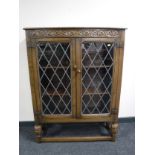 A carved oak leaded glass door bookcase