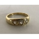 A yellow gold three stone gypsy style diamond ring, size M/N.