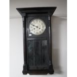 An early twentieth century oak cased wall clock with silvered dial