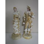 A pair of continental bisque figures of a lady and gentleman in white and gold dress.