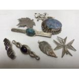 A collection of silver brooches