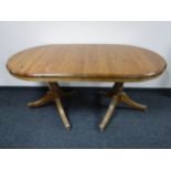 An oval Ducal pine twin pedestal extending table