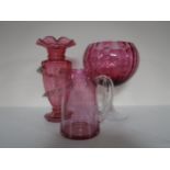 An antique cranberry glass jug and vase with later cranberry glass bowl