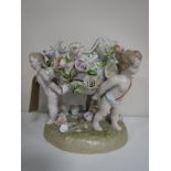 A continental bowl with flower decoration surmounted on three cherubs,