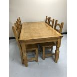 A pine farmhouse style kitchen table and six ladder backed chairs