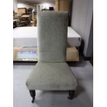 An antique bedroom chair upholstered in green floral fabric on turned legs