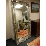A tall silvered ornate mirror, 103cm by 203cm.