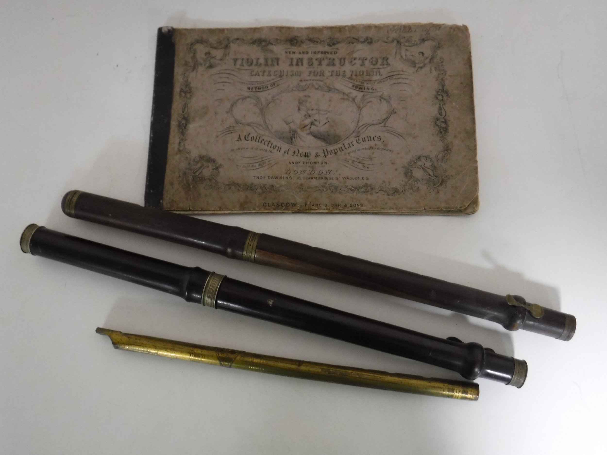 A tin whistle and two part flutes together with a vintage Violin instructor manual