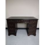 A mahogany twin pedestal writing desk with inset green leather panel
