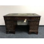 A mahogany twin pedestal writing desk with inset green leather panel