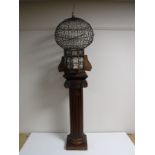 An Eastern style bird cage on carved pedestal