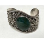 A heavy silver bangle set with malachite, 5.