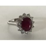 An 18ct white gold ruby and diamond cluster ring, size L.