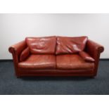 A contemporary red leather scroll armed settee