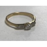 An 18ct gold diamond ring, the central stone approximately 0.2ct, size N/O, 2.3g.